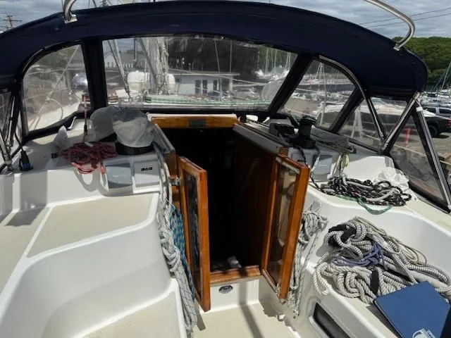 Slide: The Image of 1987 Tartan 40CB sailboat cockpit with ropes, open hatch, and covered seating area. - 16