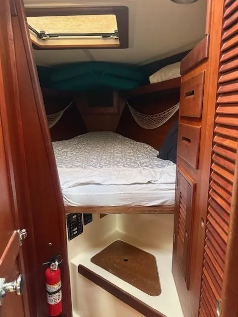Slide: The Image of 1987 Tartan 40CB yacht cabin with cozy bed, wooden interior, and storage compartments. - 21