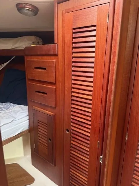 Slide: The Image of 1987 Tartan 40CB yacht interior with wooden cabinets and cozy sleeping area. - 22