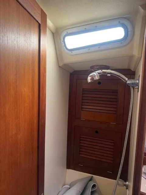 Slide: The Image of 1987 Tartan 40CB yacht interior with wooden cabinetry and showerhead. - 25