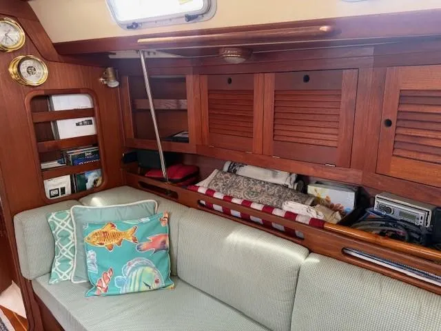 Slide: The Image of Cozy 1987 Tartan 40CB yacht interior with wooden cabinets and colorful cushions. - 31