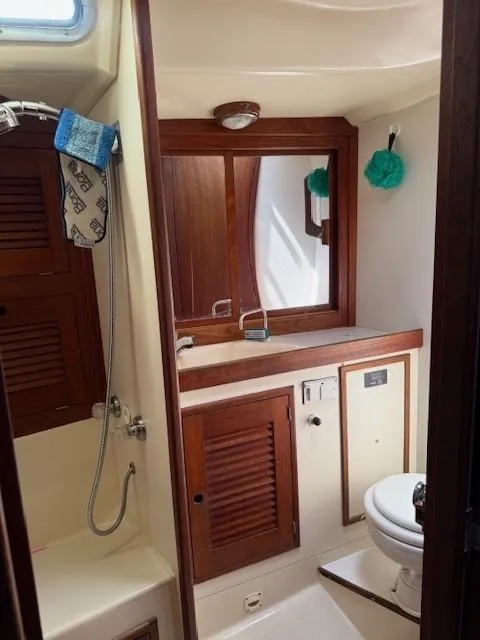 Slide: The Image of 1987 Tartan 40CB yacht bathroom with wooden cabinets, shower, and toilet. - 33