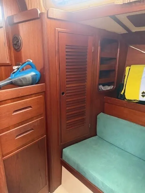 Slide: The Image of 1987 Tartan 40CB yacht interior with wooden cabinetry and teal seating. - 35