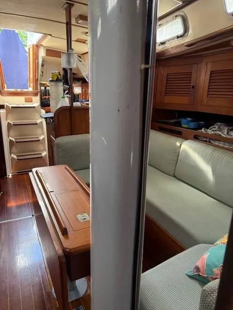 Slide: The Image of 1987 Tartan 40CB yacht interior with wooden furnishings and cozy seating area. - 40