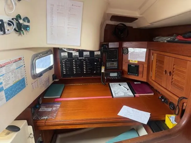 Slide: The Image of Navigation station inside a 1987 Tartan 40CB sailboat, featuring control panels and charts. - 42