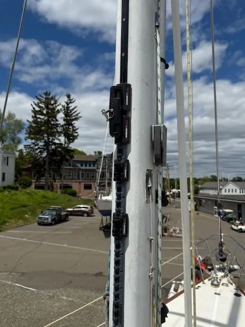 Slide: The Image of Mast of 1987 Tartan 40CB sailboat with rigging details, docked under a partly cloudy sky. - 47