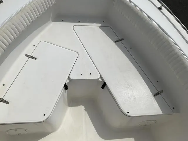 Slide: The Image of 2006 Sea Hunt Triton boat interior with white seating and storage compartments. - 7