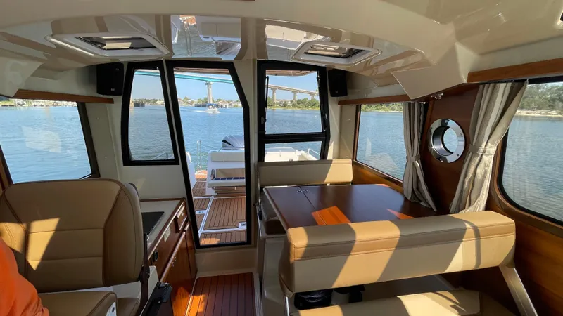 Slide: The Image of Interior of 2022 Ranger Tugs R-25 boat with seating and water view. - 14