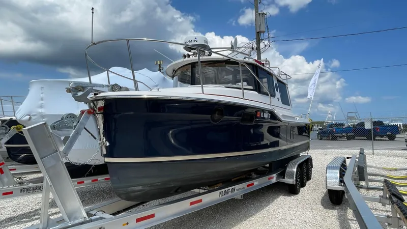Slide: The Image of 2022 Ranger Tugs R-25 boat on trailer under a cloudy sky. - 2
