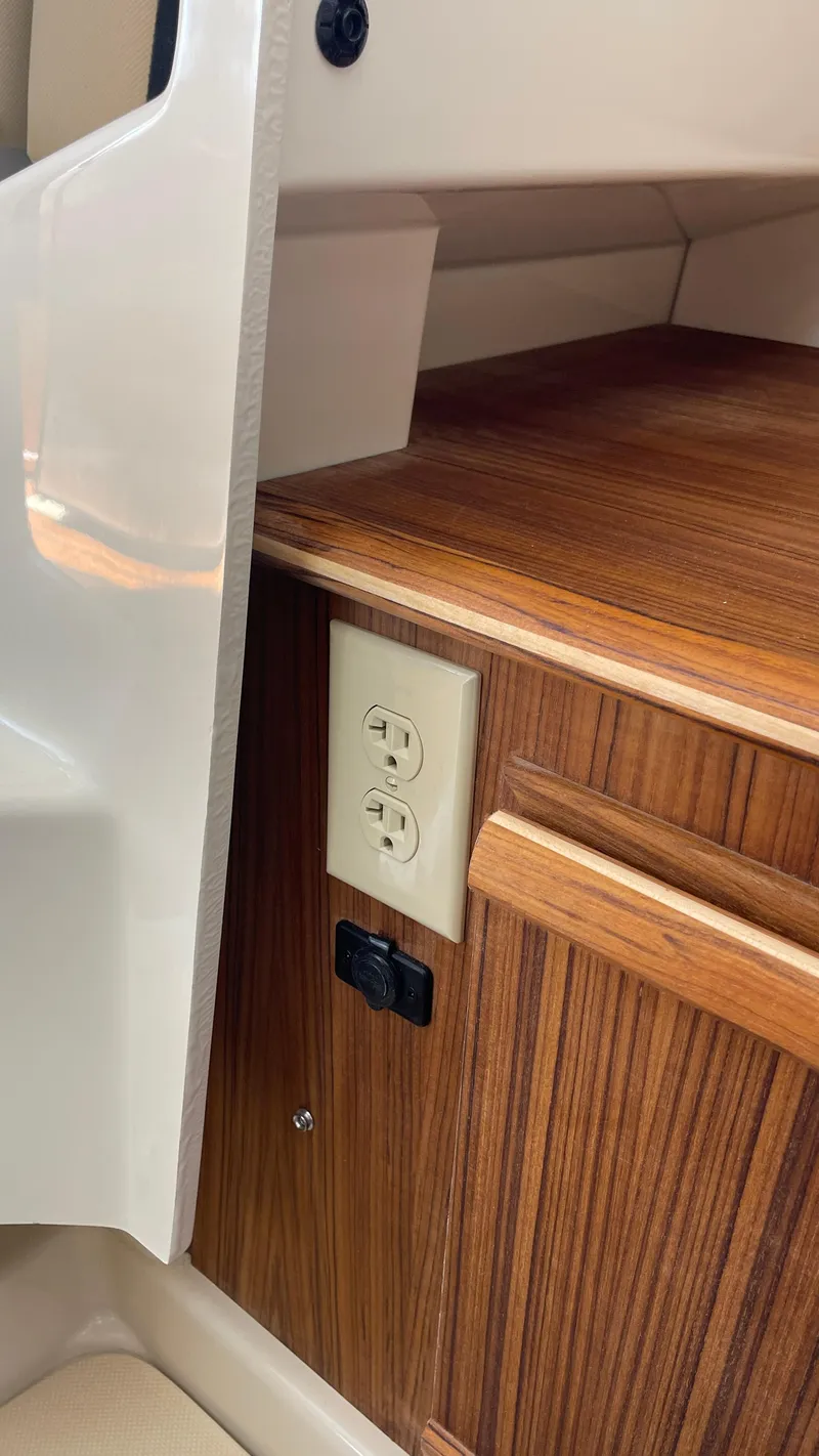 Slide: The Image of 2022 Ranger Tugs R-25 interior with wood finish and electrical outlet. - 22