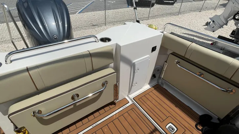 Slide: The Image of 2022 Ranger Tugs R-25 boat interior with beige seating and wood flooring. - 29