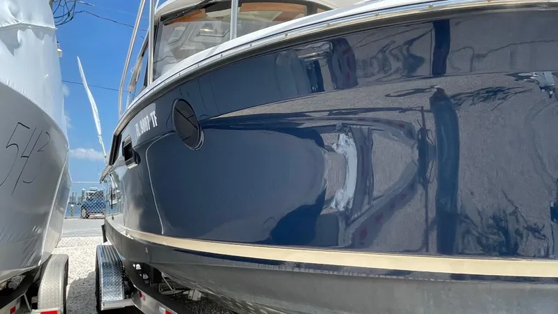 Slide: The Image of 2022 Ranger Tugs R-25 boat with sleek blue hull on trailer. - 3