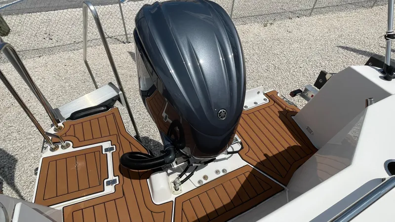 Slide: The Image of 2022 Ranger Tugs R-25 boat with outboard motor and teak deck flooring. - 30