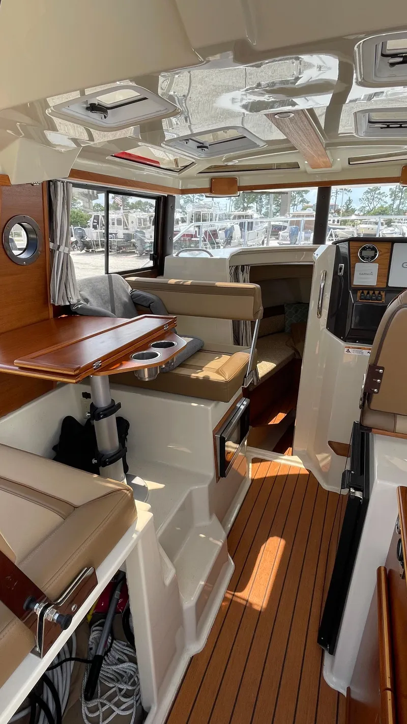 Slide: The Image of Interior of 2022 Ranger Tugs R-25 boat with wood accents and seating. - 32