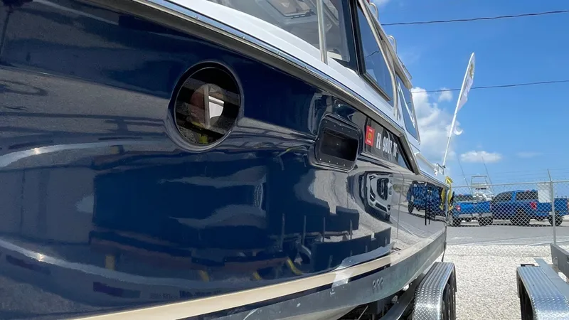 Slide: The Image of 2022 Ranger Tugs R-25 boat, blue hull, docked outdoors under a clear sky. - 4