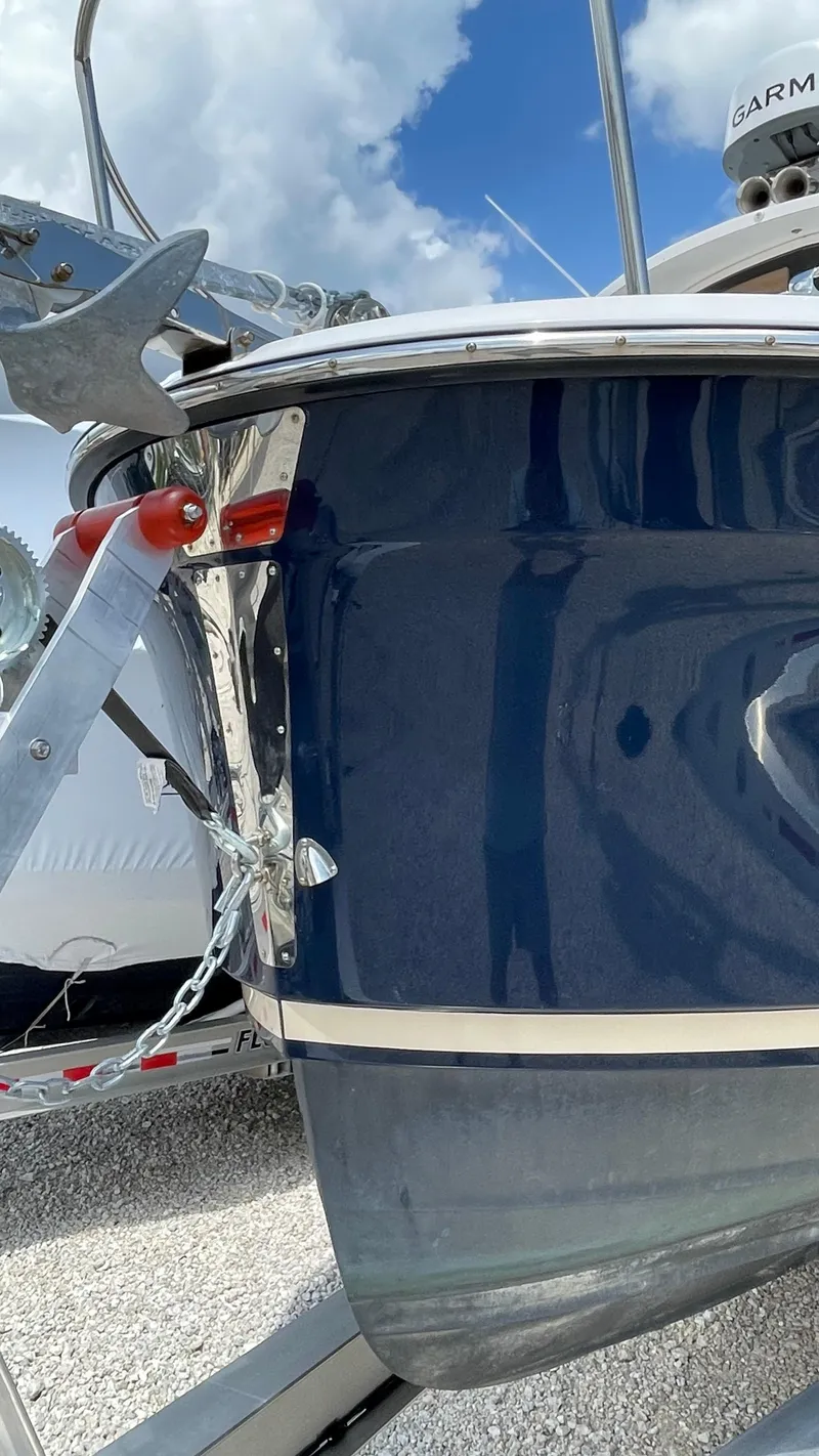 Slide: The Image of 2022 Ranger Tugs R-25 boat bow with anchor, blue hull, and clear sky background. - 5