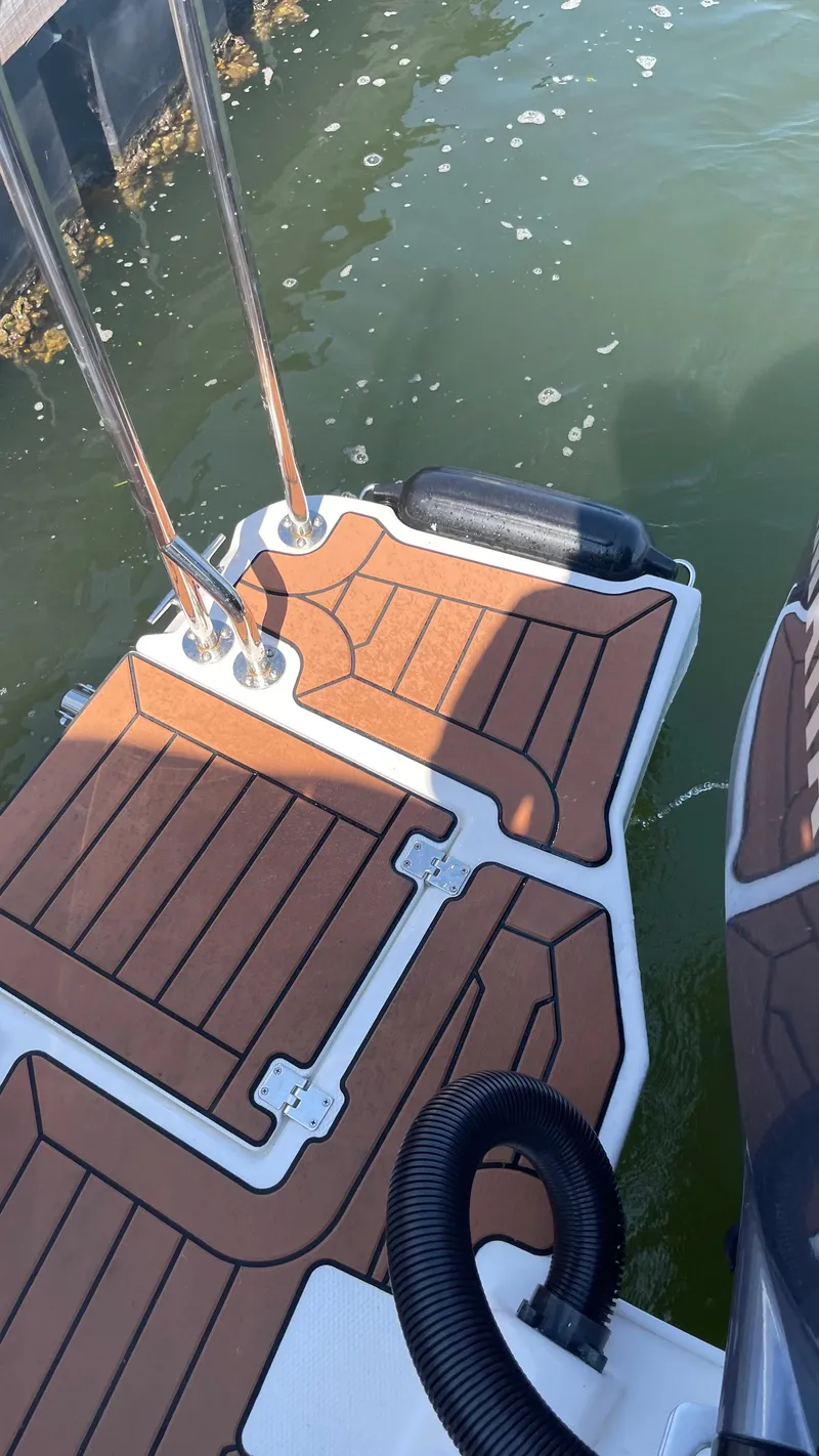 Slide: The Image of 2022 Ranger Tugs R-25 swim platform with teak-style decking on water. - 8