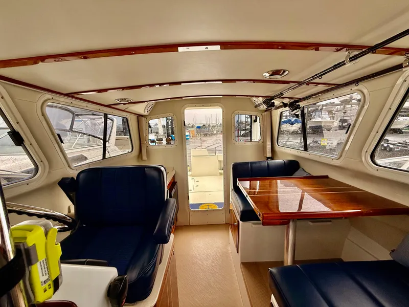 Slide: The Image of Interior of 2014 Ocean Sport Legacy #4 boat with blue seating and wooden table. - 11