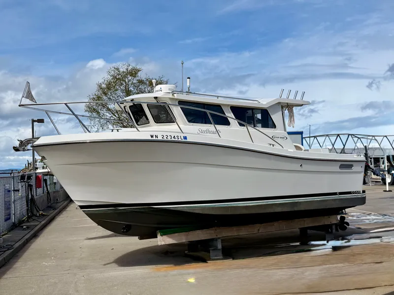 Slide: The Image of 2014 Ocean Sport Legacy #4 boat on dry dock under a cloudy sky. - 2