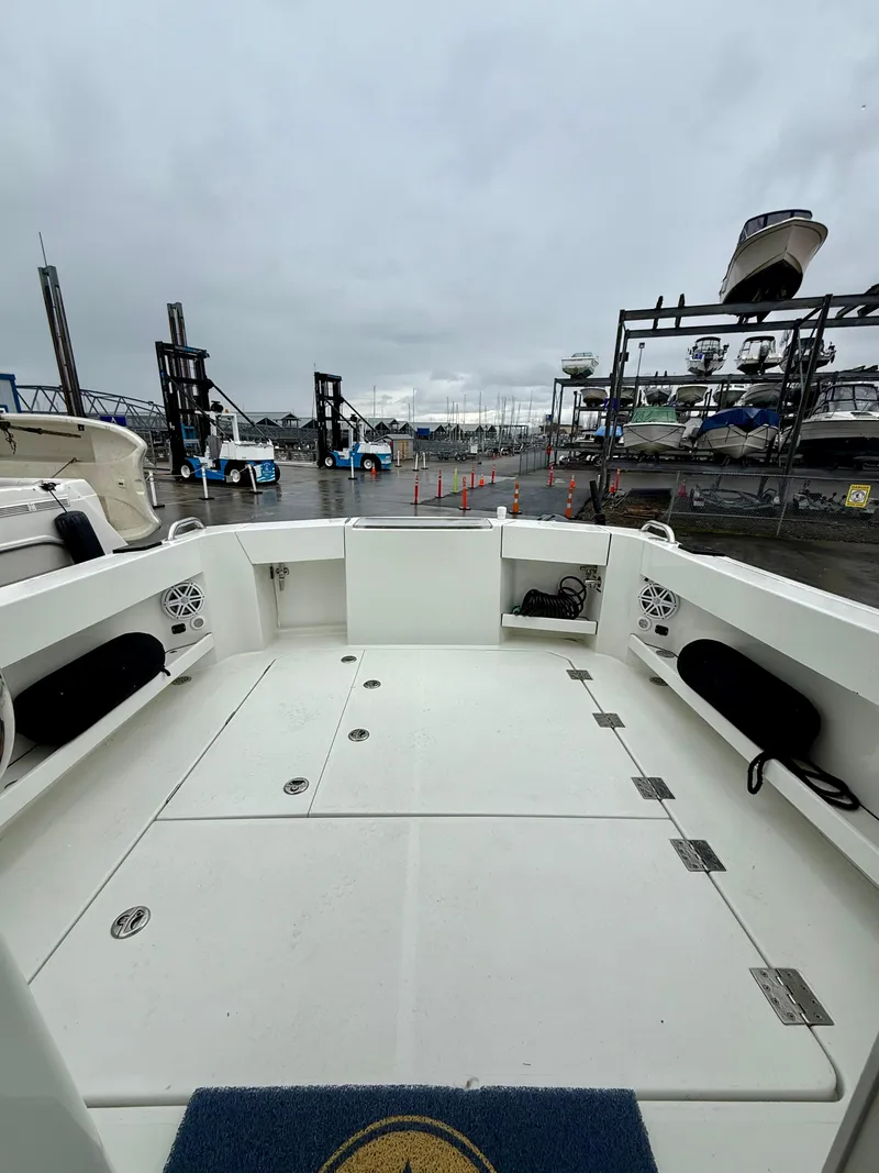 Slide: The Image of 2014 Ocean Sport Legacy #4 boat deck at marina, overcast sky, docked vessels in background. - 4