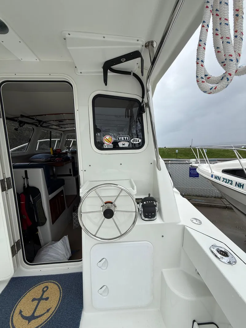Slide: The Image of 2014 Ocean Sport Legacy #4 boat interior with steering wheel and nautical decor. - 6