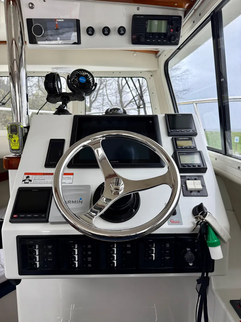 Slide: The Image of Control panel of a 2014 Ocean Sport Legacy #4 boat with steering wheel and navigation instruments. - 7