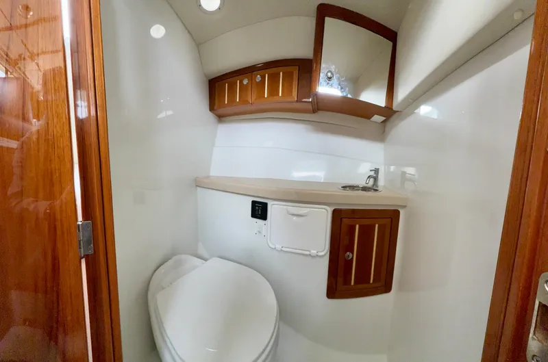 Slide: The Image of Compact bathroom in 2014 Ocean Sport Legacy #4 boat with wooden cabinets and modern fixtures. - 9