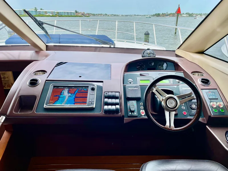 Slide: The Image of Helm of 2015 Princess F56 yacht with navigation system and steering wheel, overlooking calm waters. - 12