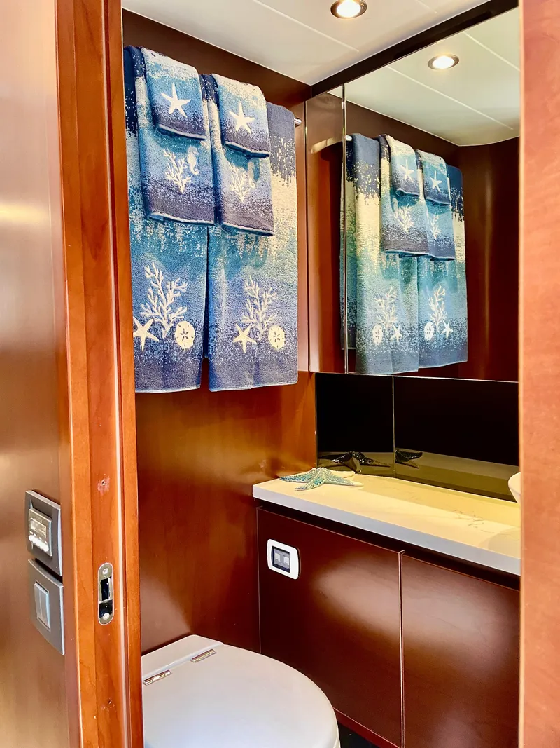 Slide: The Image of Luxurious yacht bathroom with wooden cabinetry, blue nautical-themed towels, and modern fixtures. - 19