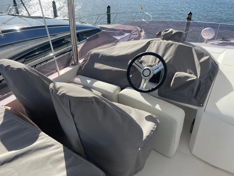 Slide: The Image of Steering area of a 2015 Princess f56 yacht, covered seats, overlooking water. - 38