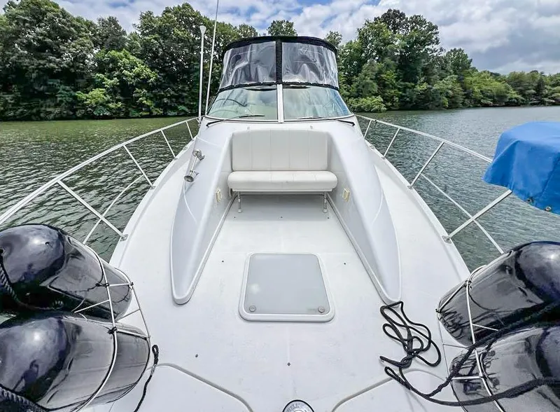 Slide: The Image of 2002 Carver 350 MARINER boat on a serene lake with lush greenery. - 10