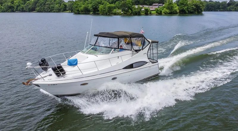 Slide: The Image of 2002 Carver 350 MARINER cruising on a lake with lush green shoreline. - 3
