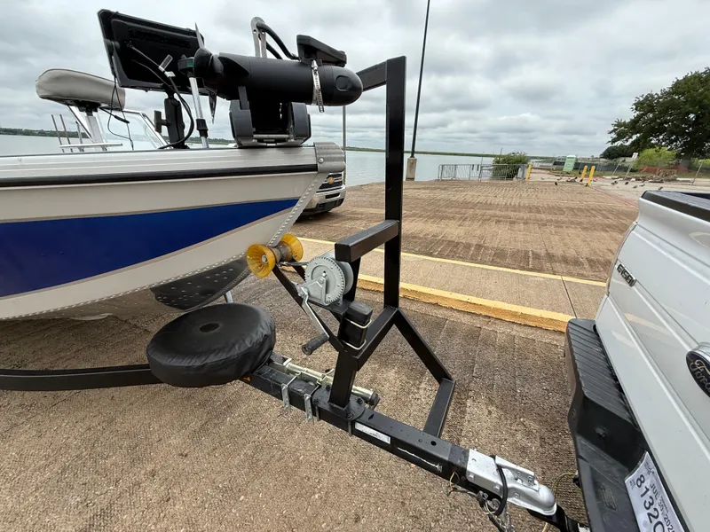 Slide: The Image of 2002 Lowe Sea Nymph V Series FM 180 boat on trailer, blue and white hull, lakeside view. - 14