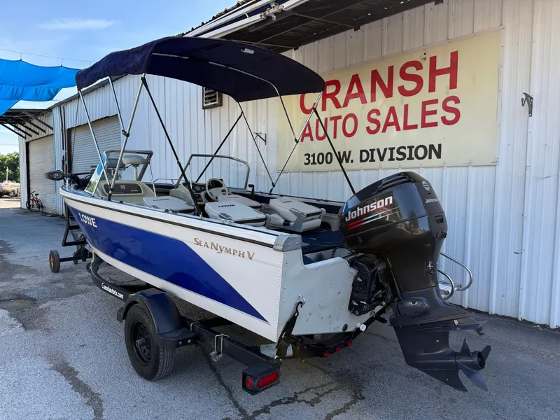 Slide: The Image of 2002 Lowe Sea Nymph V Series FM 180 boat on trailer, parked outside dealership. - 16