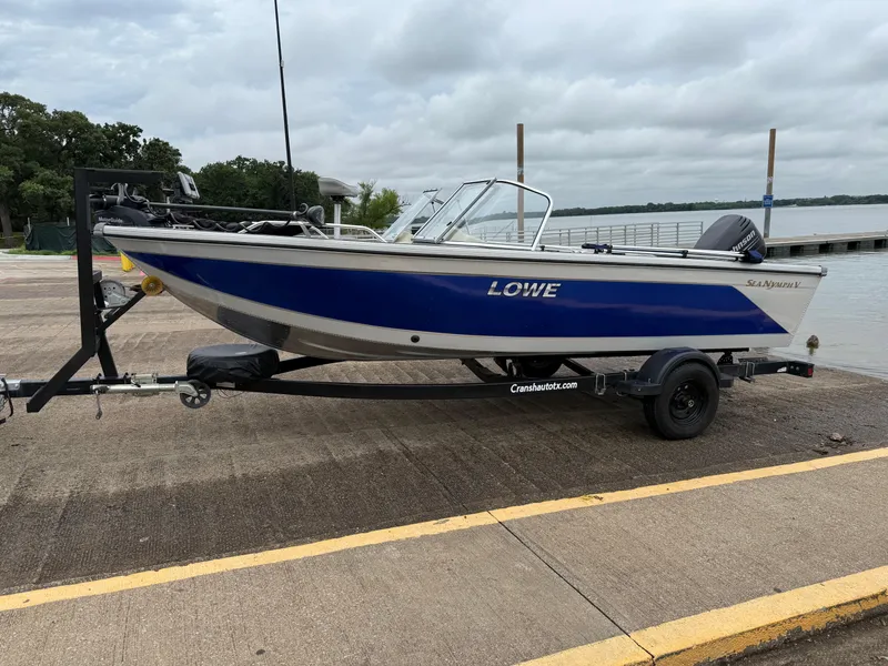 Slide: The Image of 2002 Lowe Sea Nymph V Series FM 180 boat on trailer by a lake. - 2