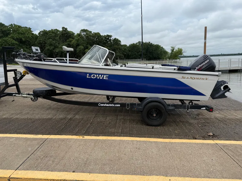 Slide: The Image of 2002 Lowe Sea Nymph V Series FM 180 boat on trailer by lakeside dock. - 3