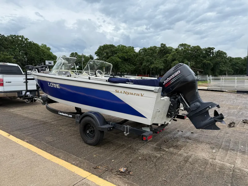 Slide: The Image of 2002 Lowe Sea Nymph V Series FM 180 boat on trailer by lakeside. - 4