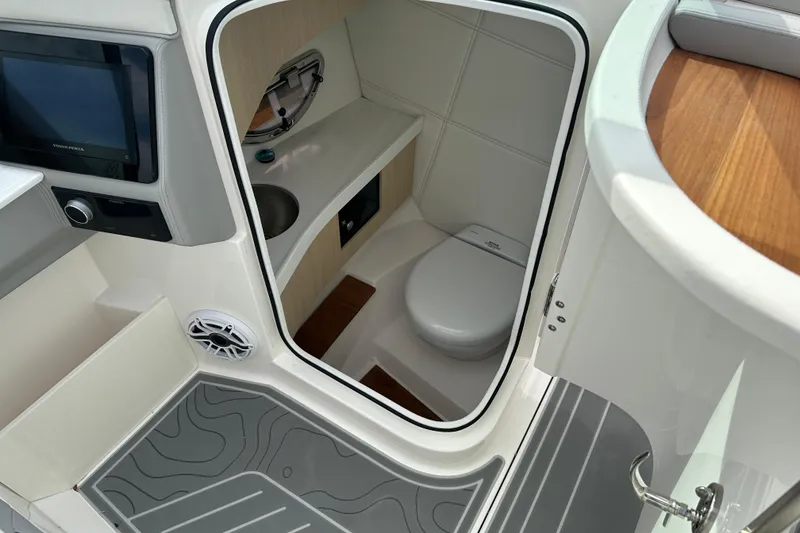 Slide: The Image of 2026 Regal LS9 boat interior with compact bathroom, featuring a toilet and sink. - 19