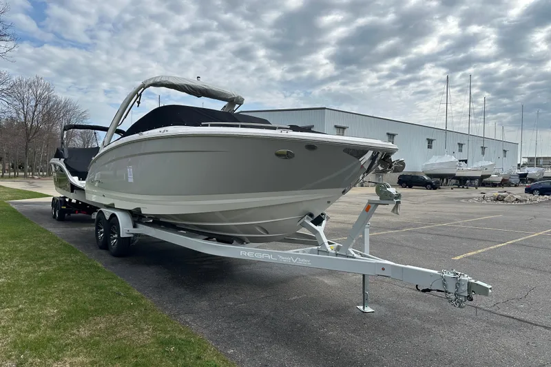 Slide: The Image of 2026 Regal LS9 boat on trailer in parking lot, cloudy sky background. - 2