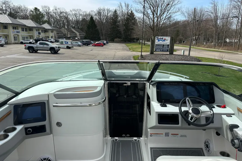 Slide: The Image of 2026 Regal LS9 boat interior with modern dashboard and steering wheel in a parking lot. - 20