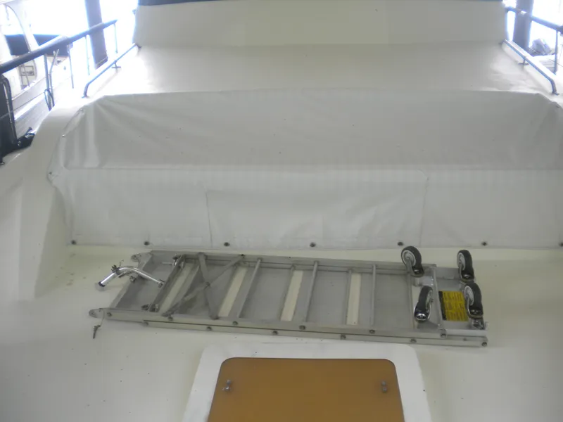 Slide: The Image of 1987 Hatteras 53 Motor Yacht deck with a folded metal ladder and white cover. - 11