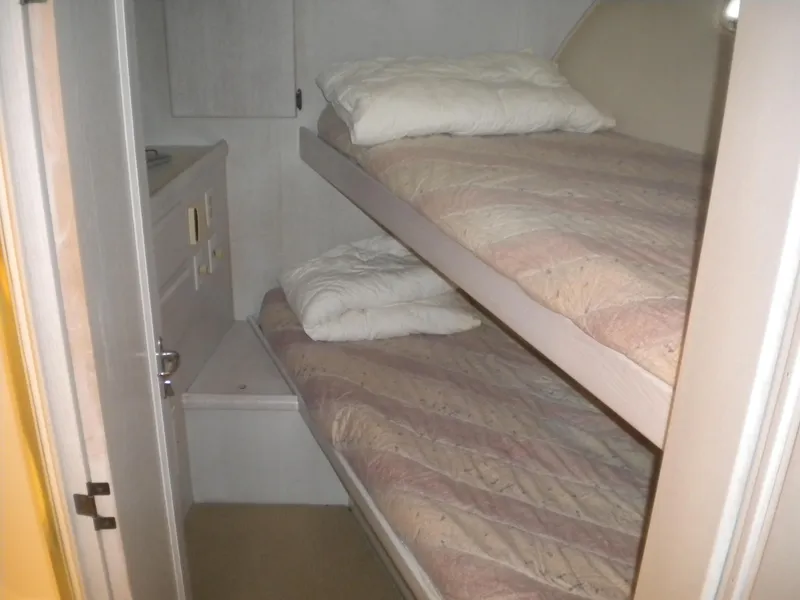 Slide: The Image of Bunk beds in 1987 Hatteras 53 Motor Yacht cabin, featuring cozy bedding and compact design. - 19