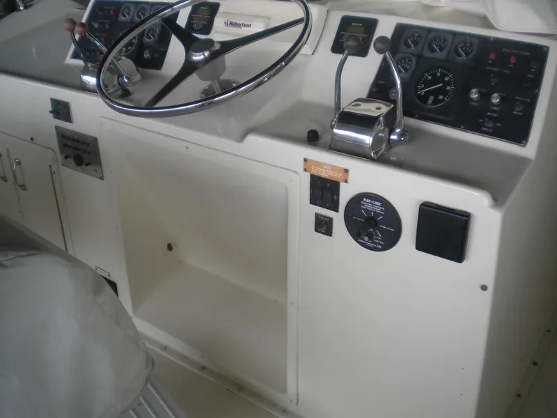 Slide: The Image of 1987 Hatteras 53 Motor Yacht helm with steering wheel and control panel. - 35