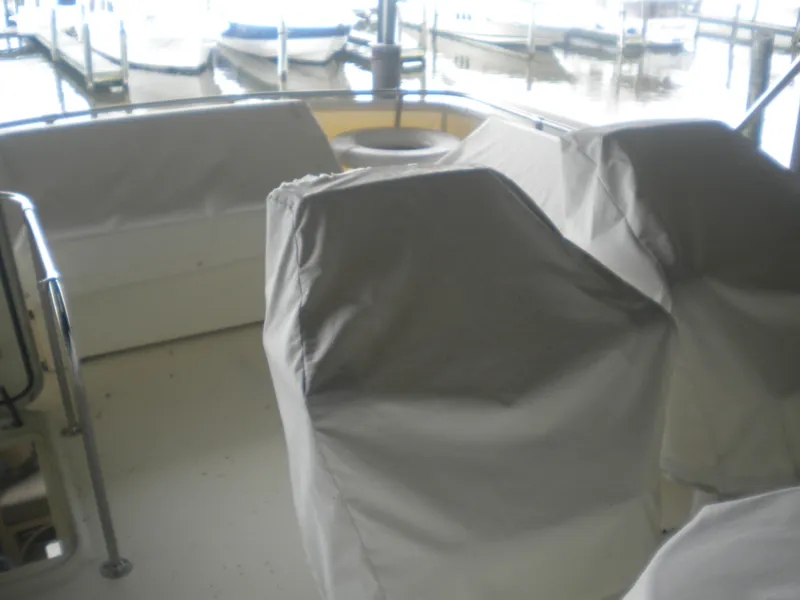 Slide: The Image of 1987 Hatteras 53 Motor Yacht interior with covered seating in a marina setting. - 37