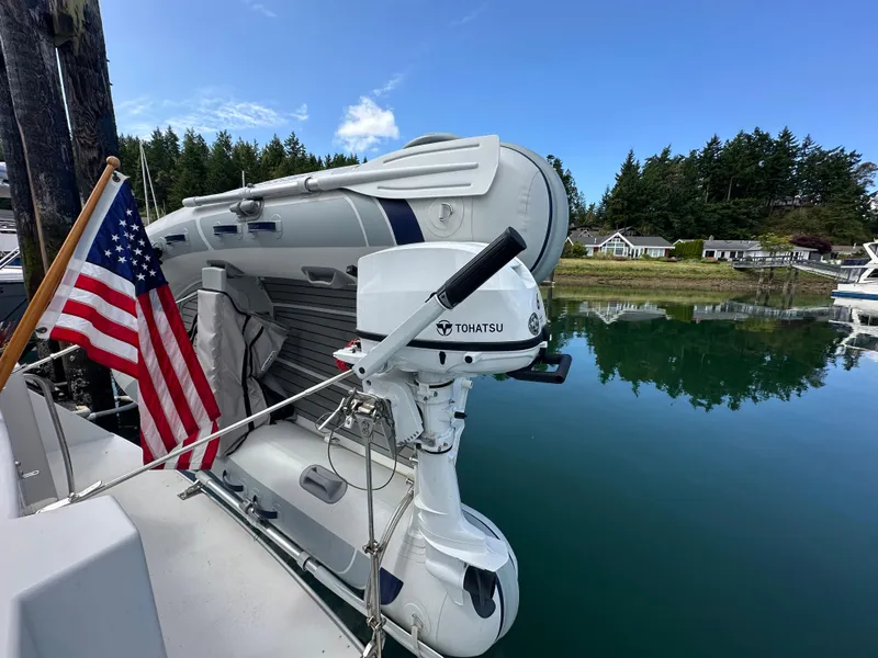 Slide: The Image of 1996 Carver Voyager with Tohatsu motor and American flag, docked by a serene lake. - 10