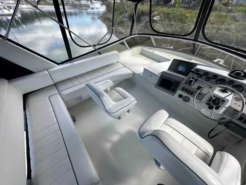 Slide: The Image of Interior of a 1996 Carver Voyager boat with white seating and control panel. - 18