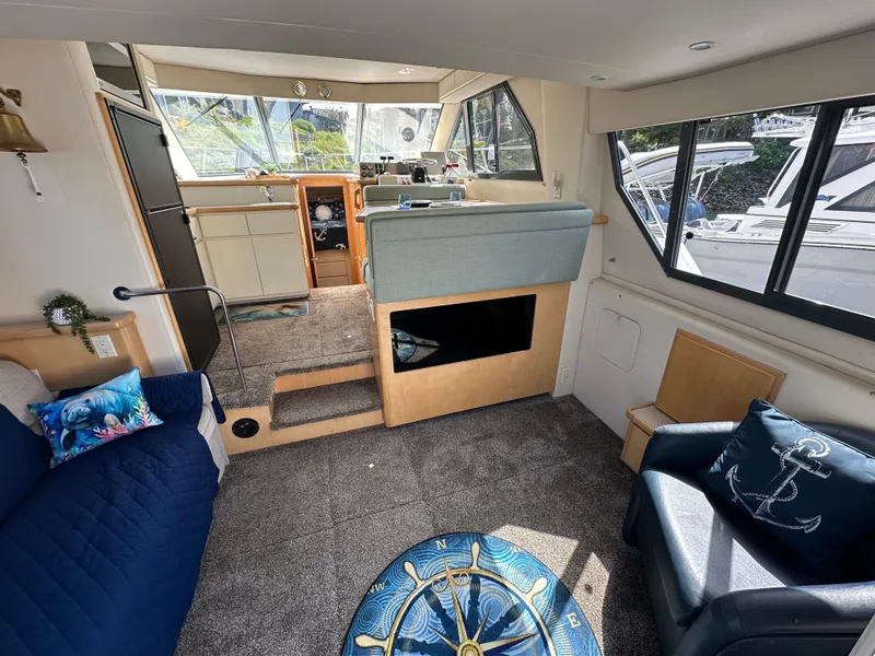 Slide: The Image of Interior of a 1996 Carver Voyager boat with nautical-themed decor and spacious seating area. - 25