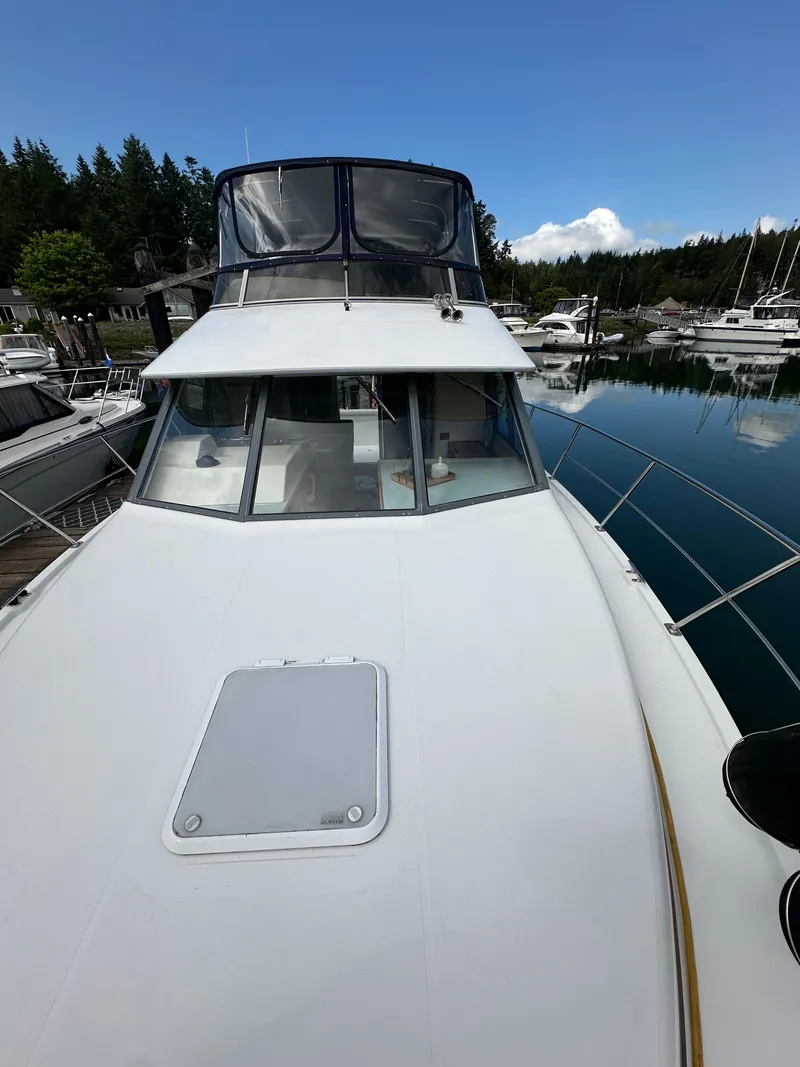 Slide: The Image of 1996 Carver Voyager boat docked in a serene marina setting. - 3