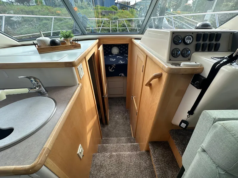 Slide: The Image of Interior of a 1996 Carver Voyager boat, featuring a compact kitchen and cozy cabin area. - 30