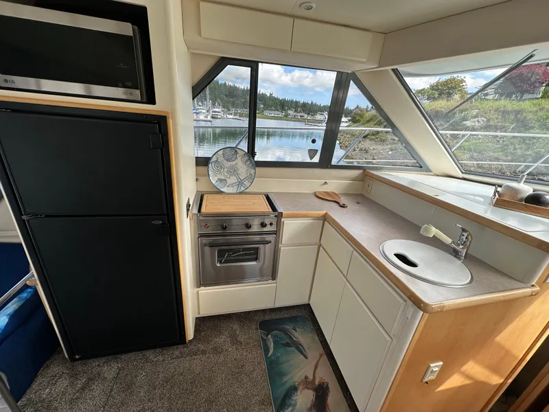 Slide: The Image of Interior of 1996 Carver Voyager kitchen with stove, sink, and scenic window view. - 31